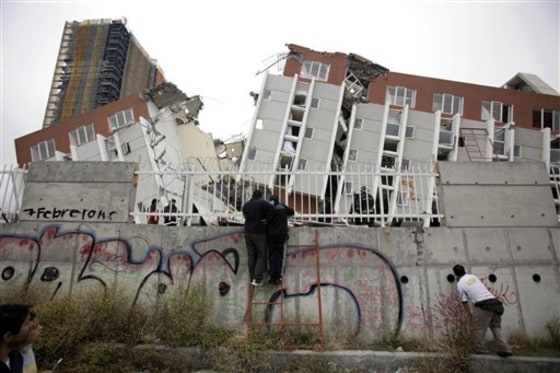People look at a collapsed building in Concepcion, Chile, on Sunday.